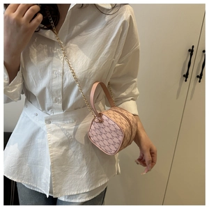 Detail view of the pink retro handbag featuring a gold chain strap and M letter prints