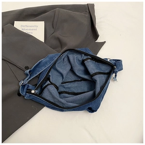Detailed interior of a deep blue denim tote bag with black zipper and spacious compartment