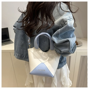 Gros plan d'un sac seau en cuir PU bleu et blanc bicolore sur un mannequin.