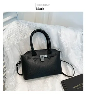 Detail der schwarzen Handtasche aus Narbenleder mit Silberverschluss und Trapezform