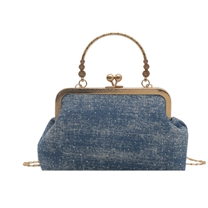 Vintage blue denim kiss-lock handbag featuring elegant gold-tone hardware and chain strap