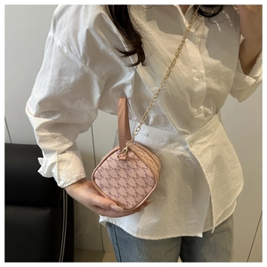 Detailed shot of a pink crossbody bag with M-pattern print and golden chain strap