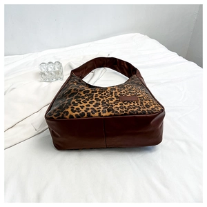 Détail du sac hobo à motif léopard avec bandoulière et base en cuir marron foncé