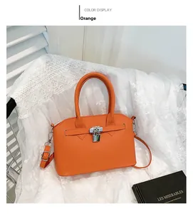 Details der orangefarbenen Handtasche aus Narbenleder mit silbernem Schloss und Riemen