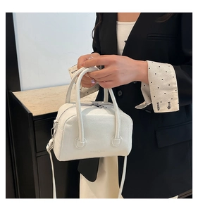 Detailed close-up of white lychee leather texture and FASHION logo on the handbag