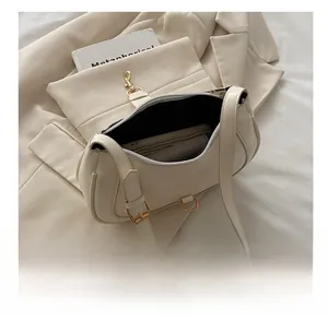 Vue de dessus d'un sac hobo beige ouvert montrant l'intérieur spacieux sur fond neutre