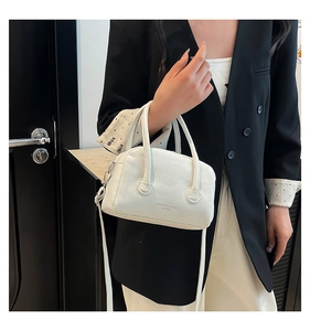 Detail of white lychee leather texture and golden logo on fashion women handbag
