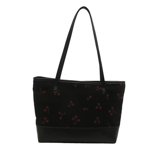 Large black tote bag with red cherry prints and durable faux leather base for commuting