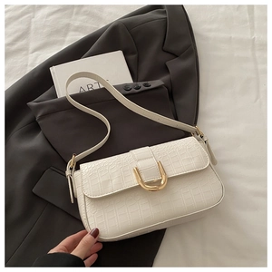 Detail of white crocodile embossed PU leather bag with elegant gold U-shaped metal buckle