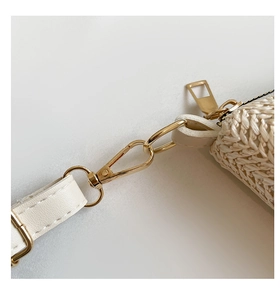 Detail of white leather strap with golden metal lobster clasp and woven texture