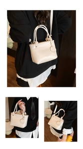 Close-up of cream white lychee texture bag with fashion design embossing and smile charm