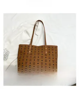 Close-up of the brown leather tote bag showing bear print patterns and rivet details