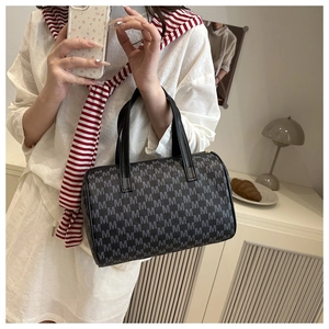 Dettaglio di una borsa tote vintage nera con motivi M grigi e manici in pelle pregiata
