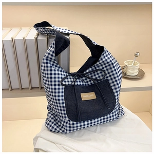 Detail of blue checkerboard canvas tote bag featuring a denim pocket and ribbon bow tie