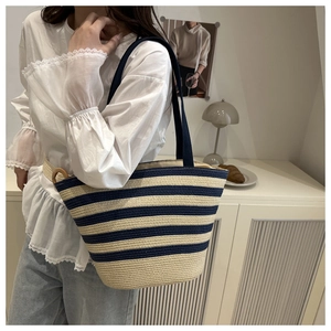 Detail view of woven tote bag with navy blue and beige stripes and durable fabric handles