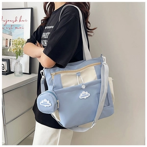 Detail of light blue tote bag with cloud embroidery, small pouch and adjustable strap