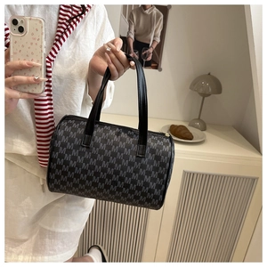 Dettaglio borsa Boston vintage in jacquard con lettere M e manici in pelle nera e zip