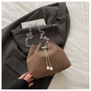 Detail der braunen Web-Eimertasche mit Silberkette und eleganten Perlen-Kordelzügen