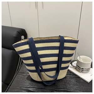 Detailed view of striped straw tote bag with wide handles and woven texture finish