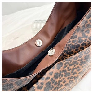 Détail du sac cabas léopard avec fermoir magnétique et bordure en similicuir brun