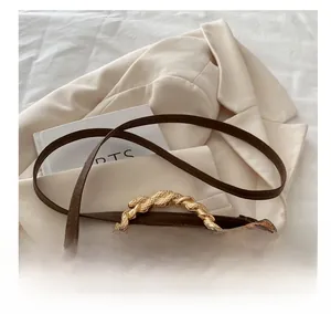 Detail of leopard print bag with golden spiral metal handle and adjustable brown strap