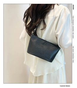 Détail du sac seau en cuir grainé noir avec boucle métallique et coutures précises