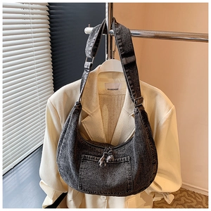 Detail of dark grey washed denim hobo bag featuring adjustable strap and contrast stitching