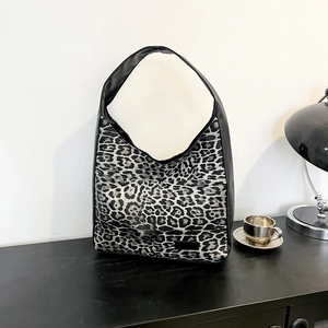 Sac cabas argenté à imprimé léopard sur table en bois noir avec décoration