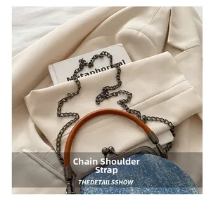 Close-up of vintage denim handbag featuring metal chain strap and leather handle