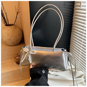 Silver metallic shoulder bag detail with pearl bow charm and drawstring fringe