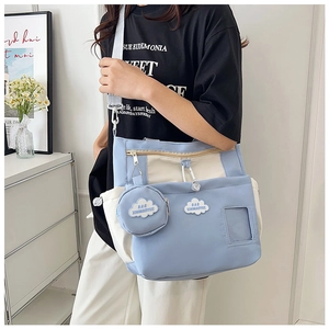 Detail of light blue canvas tote bag with cloud pouch and adjustable gray shoulder strap