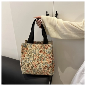 Detail of vintage floral jacquard tote bag featuring colorful flower embroidery and black handles