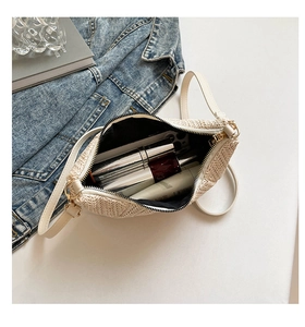Detail showing inner capacity of the beige woven crossbody bag with daily essentials