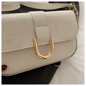 Close-up of white crocodile pattern PU shoulder bag with elegant golden U-shaped lock
