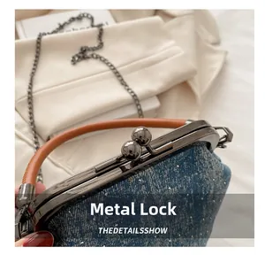 Detail of vintage denim bucket bag featuring a rhinestone hardware lock and chain strap