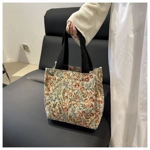 Detailed macro view of retro floral jacquard weaving and black canvas strap on the tote