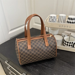 Borsa tote retrò con motivo M e manici in pelle marrone su tavolo in legno scuro