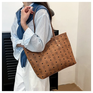 Detail of vintage brown tote bag with cartoon bear print and golden rivet accents