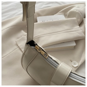 Détails de couture premium et fermeture éclair dorée sur un sac à bandoulière en cuir blanc