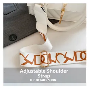 Close-up of adjustable wide fabric strap with artistic letters on a white handbag