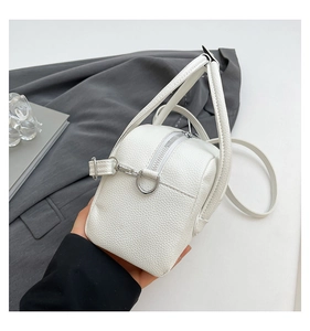 Detailed shot of white lychee pattern PU leather handbag with silver metal hardware