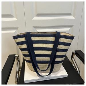 Close-up of a striped woven tote bag resting on a book in a modern interior setting