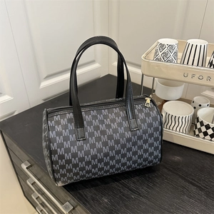 Borsa tote vintage grigio scuro con motivo M bianco e cerniera dorata in un interno casa