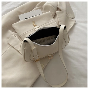 Vue détaillée du sac croissant beige avec garniture dorée et bandoulière réglable