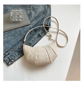 Detail of cream woven moon bag showing V-pattern texture and gold metal adjustment buckle