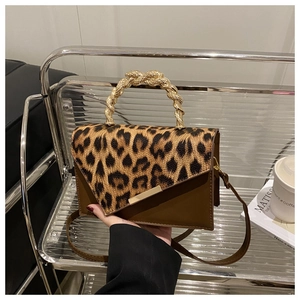 Detail of leopard print flap bag with gold chain handle and metal buckle on leather