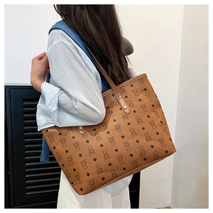 Close-up of brown tote bag showing bear pattern print and metallic rivet details