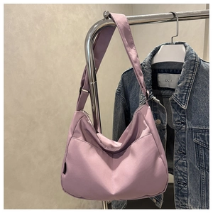 Detail view of light purple nylon tote bag with adjustable strap on a metal hanger