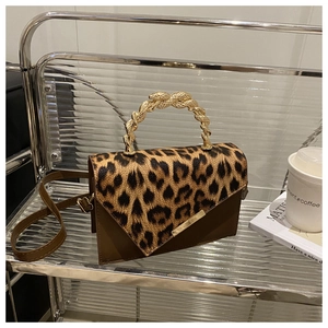 Close-up of leopard print handbag with unique golden snake handle and textured leather