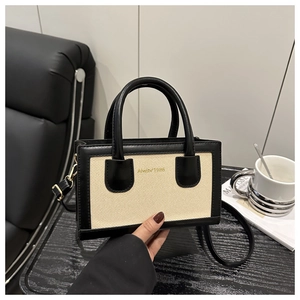 Detail of the Studio 1986 contrast color handbag with canvas texture and leather trim